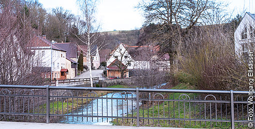 Häuser an einem Fluss mit Brücke