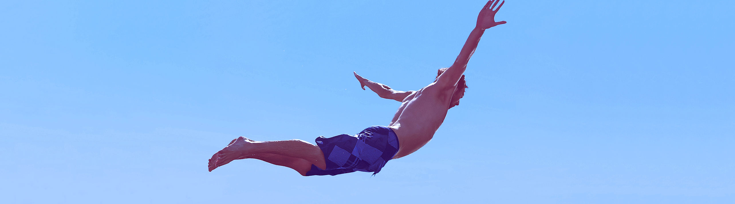Person, die in der Luft fliegt beim Sprung ins Wasser